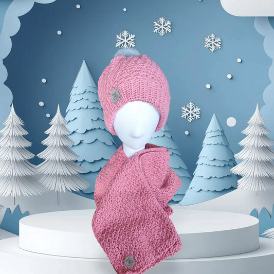 Blush Rose handmade crochet beanie and scarf set in soft pink, styled on a mannequin with a winter-themed backdrop.