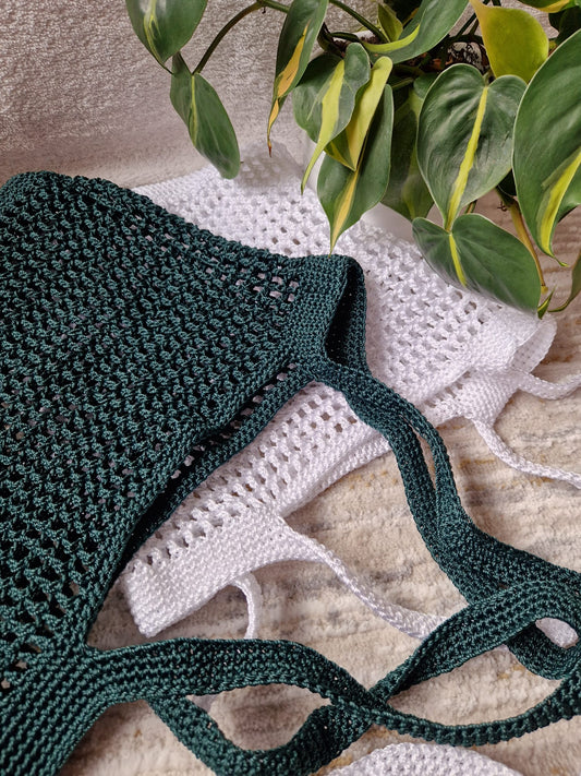 White and green Breezy Market Crochet Tote Bags stacked flat to show their size, shape, and knit pattern.