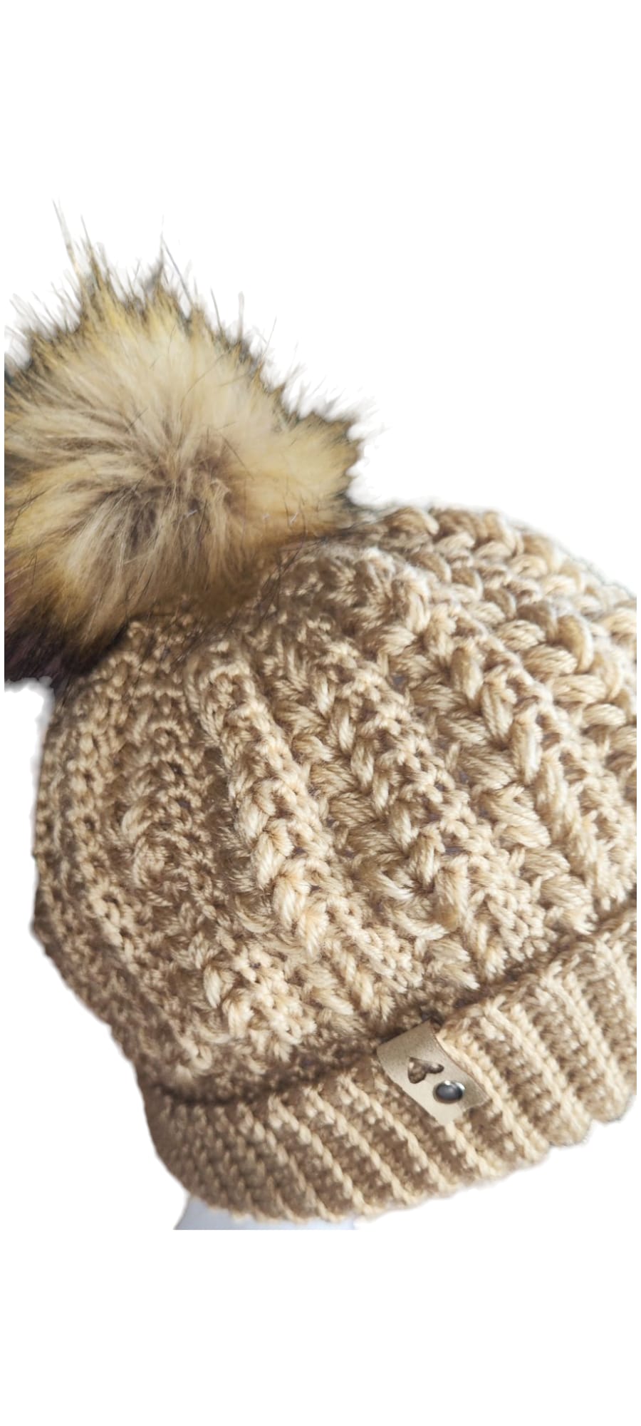 Close-up view of the Cozy Knit Beanie highlighting its handmade stitches and plush beige pom-pom.