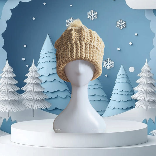 Cozy beige crochet beanie with faux-fur pom-pom styled on a mannequin, set against a snowy winter backdrop.