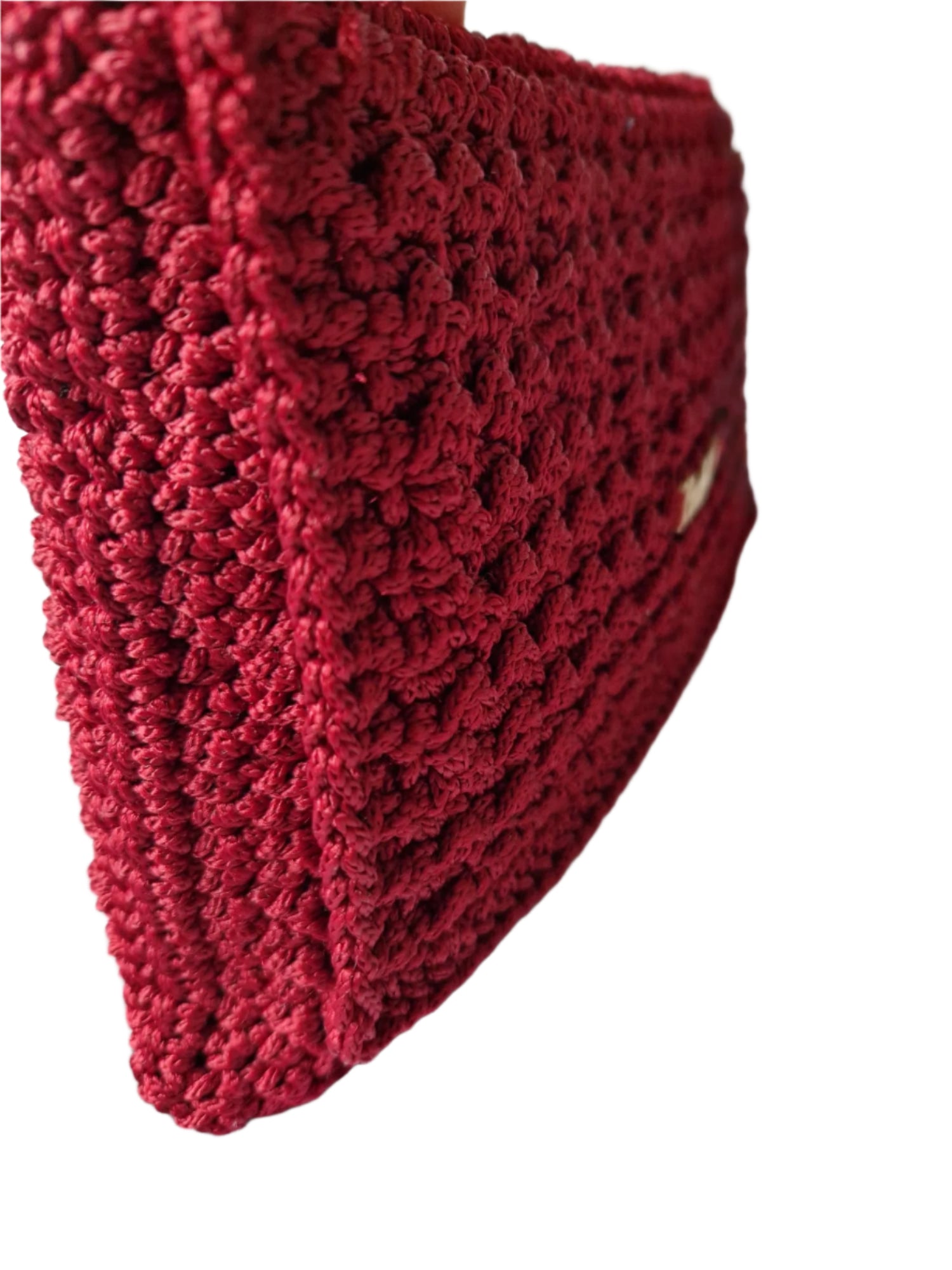 Angled view of the Crimson Luxe Clutch revealing its thickness, shape, and smooth fold-over construction.