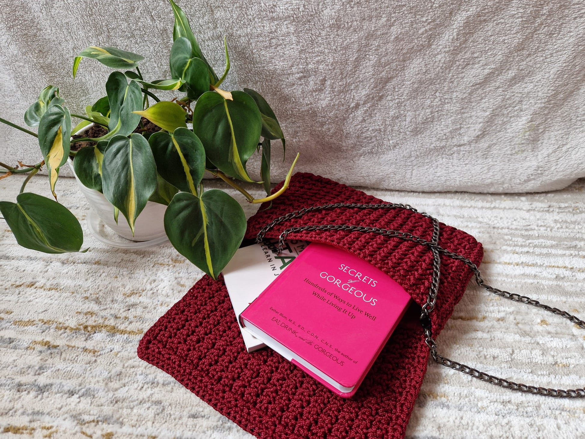 The Crimson Luxe Crochet Clutch in a cozy setting, styled for a chic, handcrafted, and classy look.