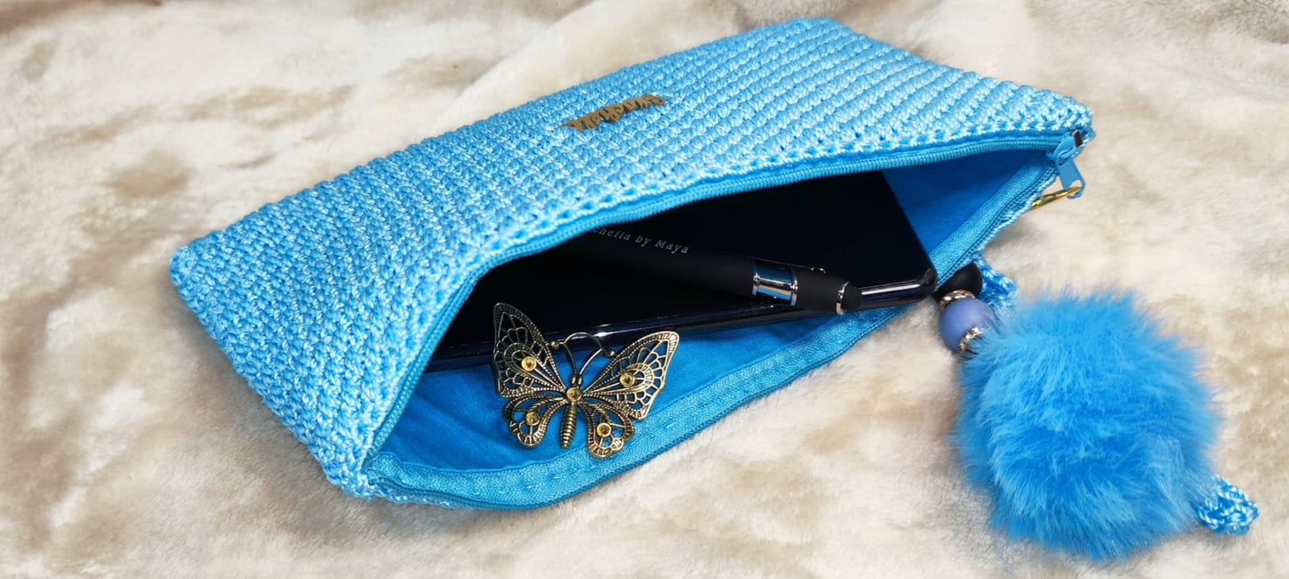 Full view of the blue clutch with gold-toned accents and keychain.