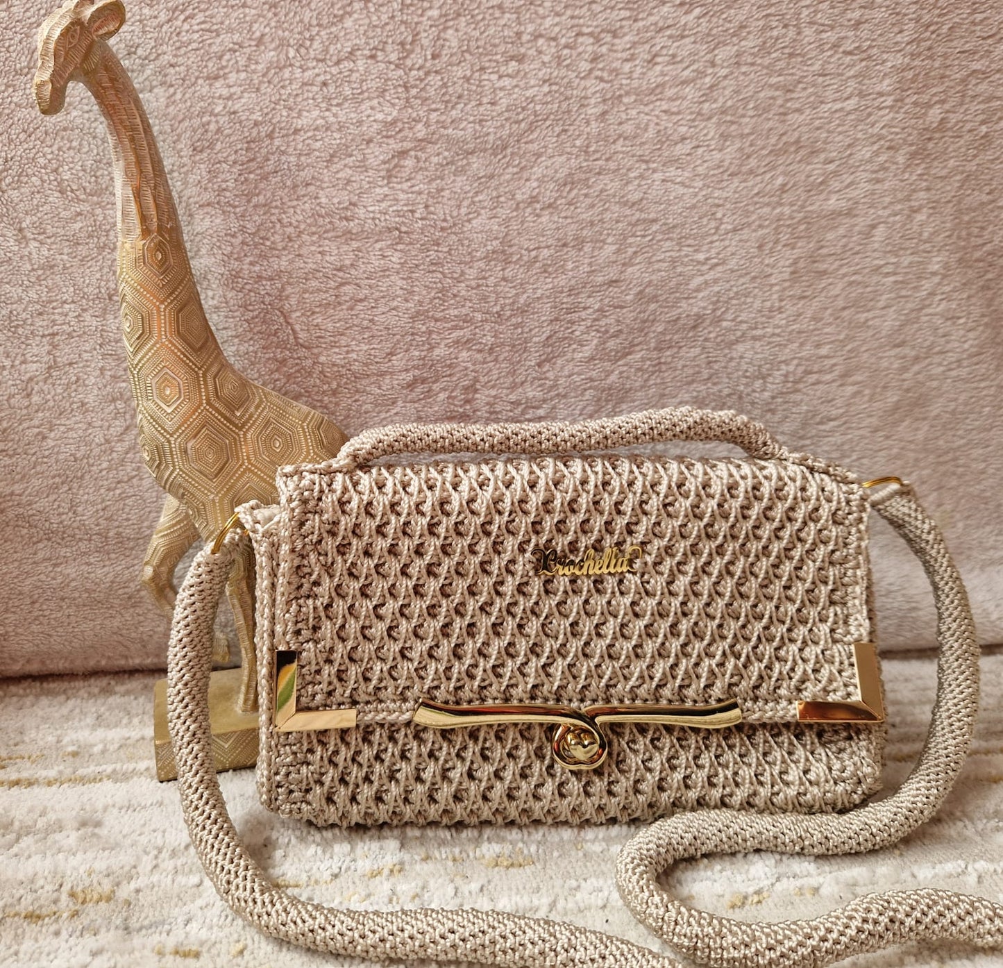 Neutral beige Diamond Luxe Crochet Bag with smooth metallic accents and a delicate top handle.