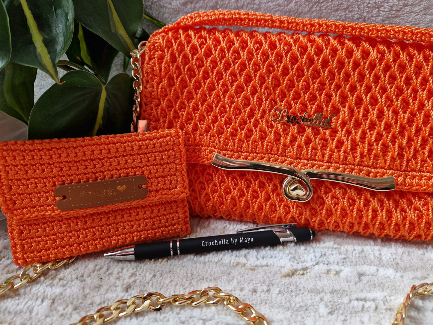 Vibrant orange Diamond Luxe Crochet Bag with gold accents and a bold, geometric pattern.