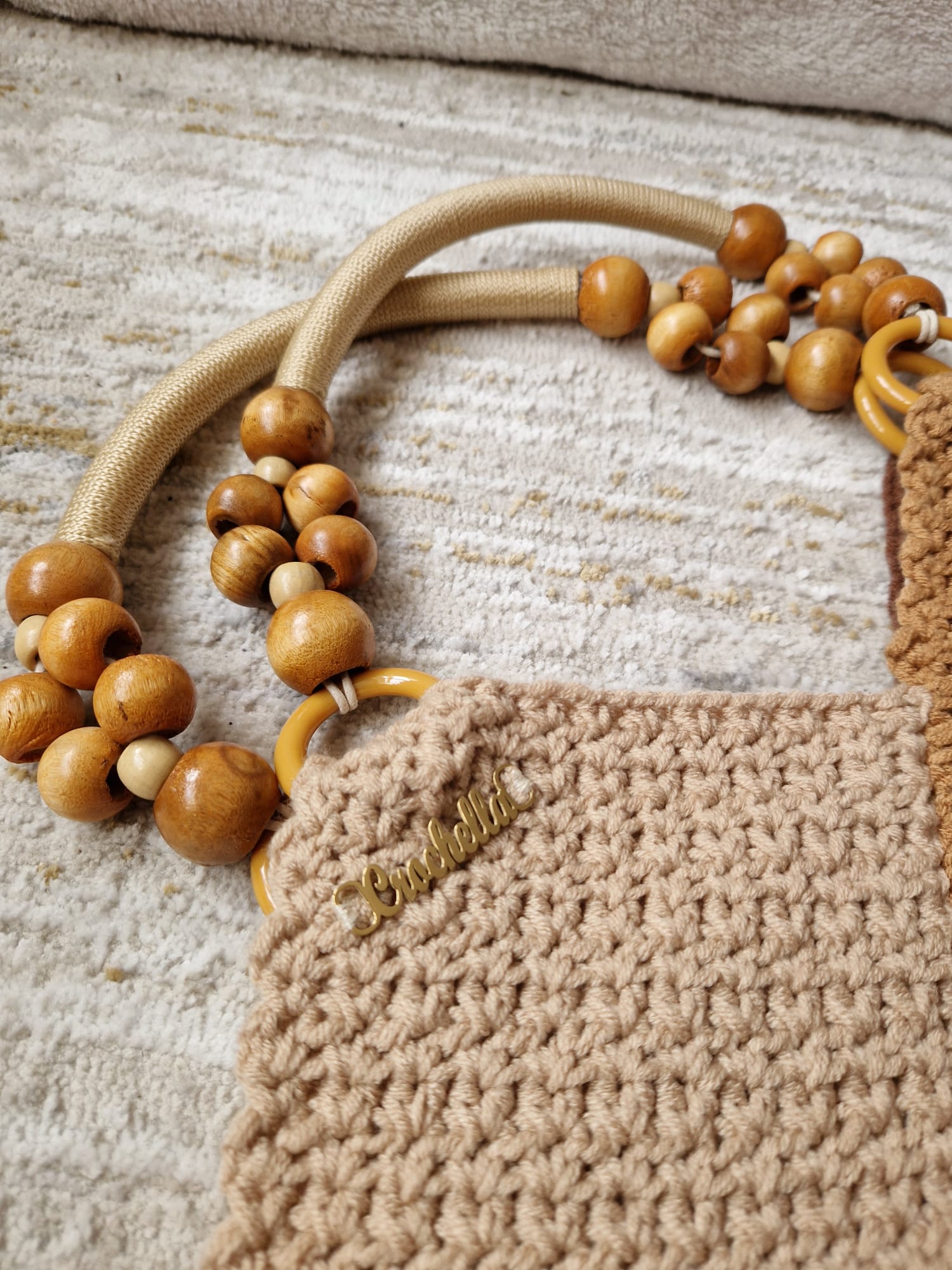Close-up of the Earthy Boho Bag's textured crochet panels and the unique wooden bead shoulder strap with yellow ring accents.