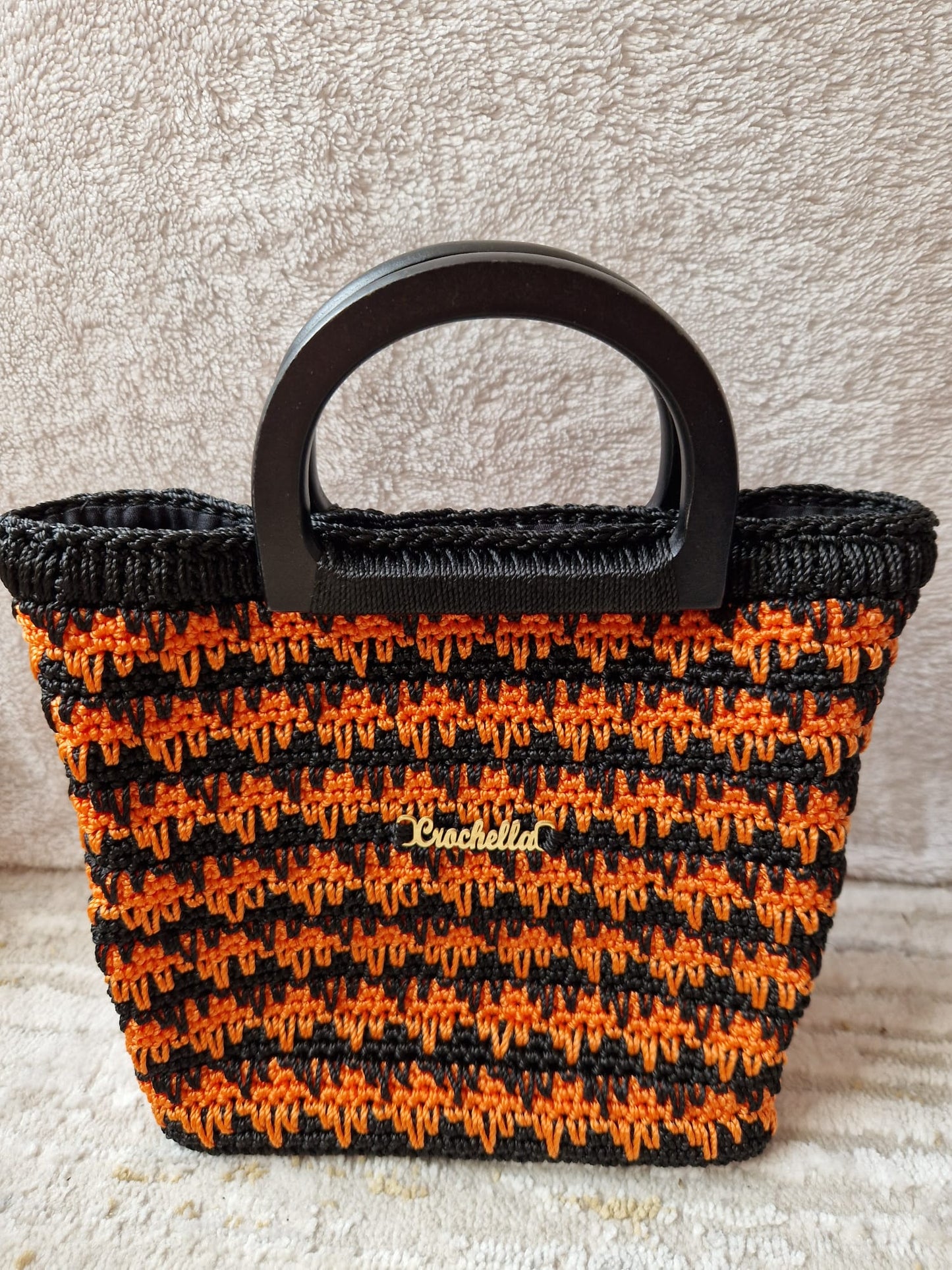 Midnight Ember Crochet Handbag with bold orange and black crochet stripes, paired with a black handle for contrast.