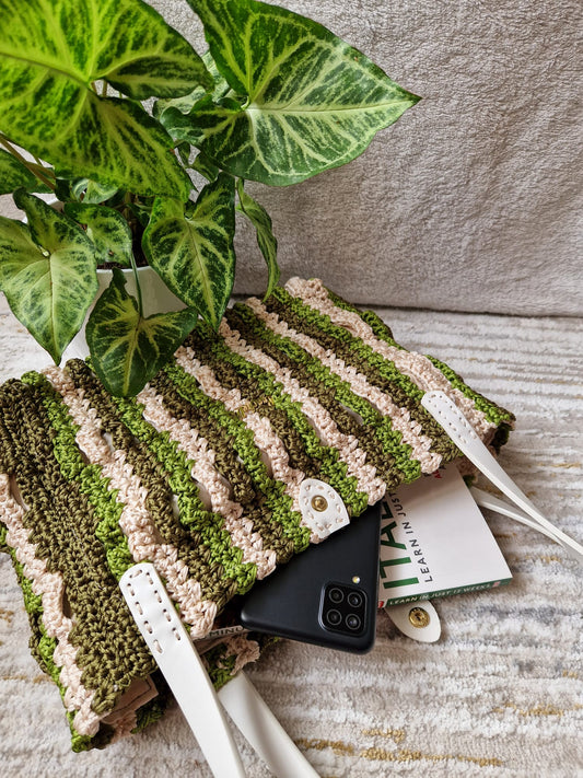 Close-up of the Forest Waves Crochet Bag showing wavy stitch pattern in green, beige, and olive with the Crochella logo.
