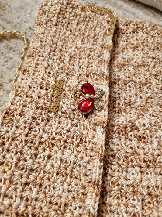 Angled view of the Golden Elegance Crochet Clutch highlighting its fold-over flap and shimmering thread details.
