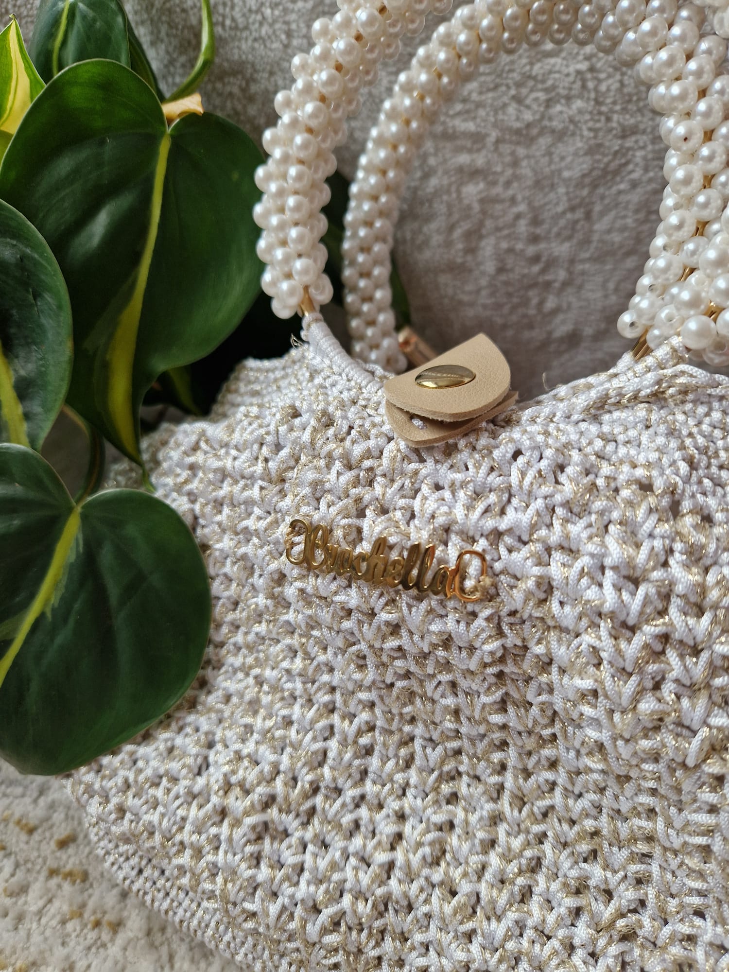 Close-up of the Pearl Luxe Bridal Bag showing pearl handle detail and metallic crochet stitches.