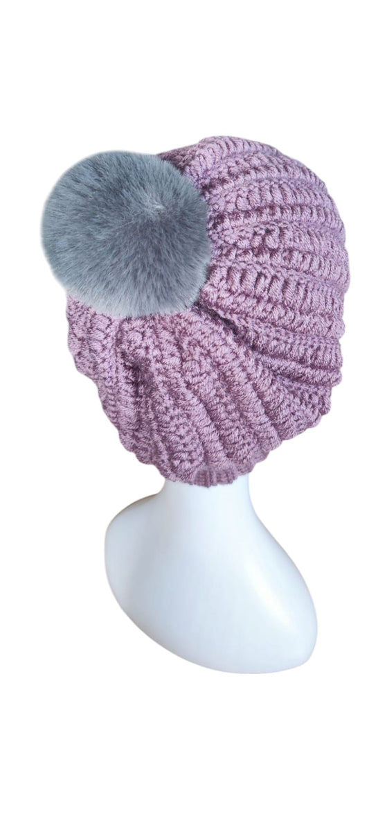 Flat lay of the Soft Lavender crochet beanie showing ribbed stitch texture and plush pom-pom detail.