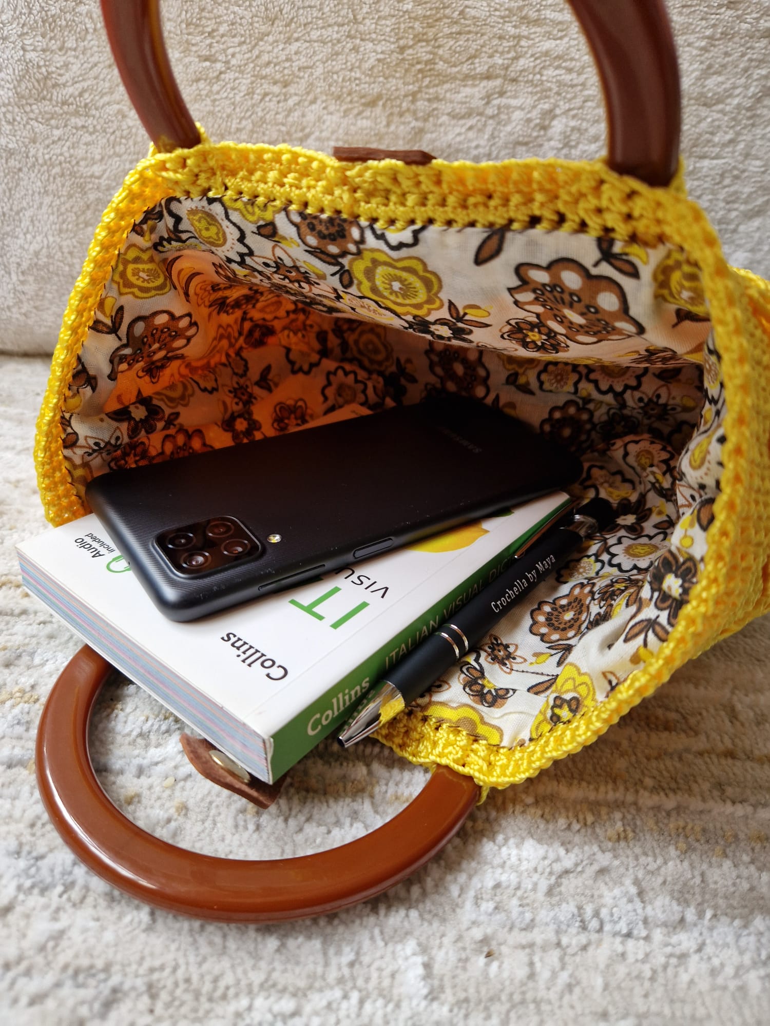 Angled view of the Sunburst Bloom Handbag showcasing its 3D textured crochet work and structured silhouette.