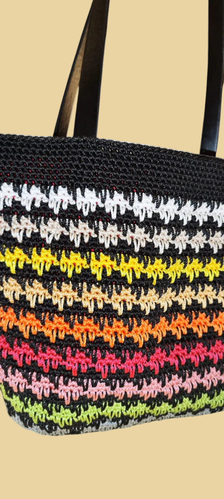 Angled shot of the Sunset Stripes Crochet Tote emphasizing its structure, size, and texture from side view.