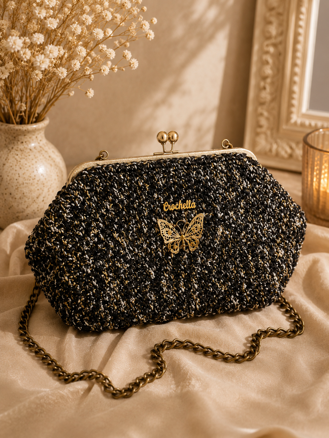 Black textured handbag with gold butterfly design and 'Bucheli' branding on a light fabric surface.