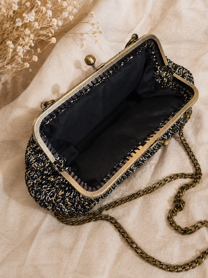 Vintage-style handbag with chain strap on a textured fabric background