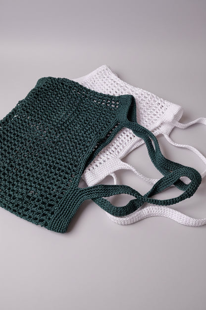 White and green Breezy Market Crochet Tote Bags stacked flat to show their size, shape, and knit pattern.