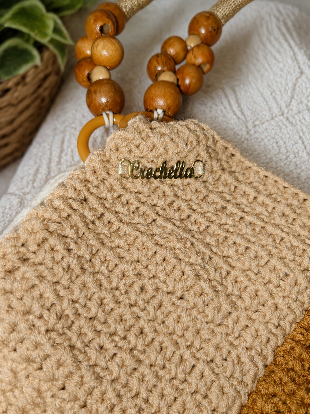 Close-up detail of a handmade crochet handbag featuring textured stitching and wooden beaded handles