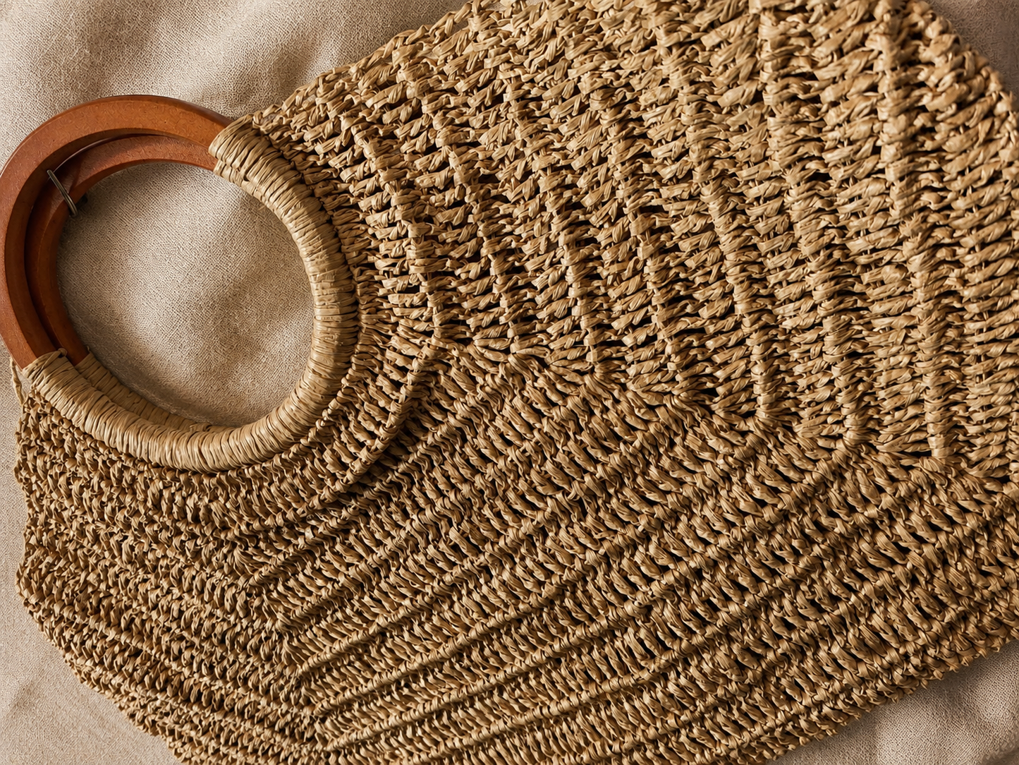 Handmade raffia crochet beach tote bag with wooden handles in natural beige color