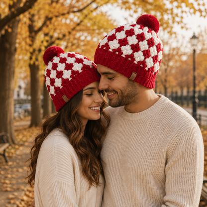 Handmade red and white crochet beanie styled on a mannequin, featuring classic granny square pattern and fluffy pom-pom.