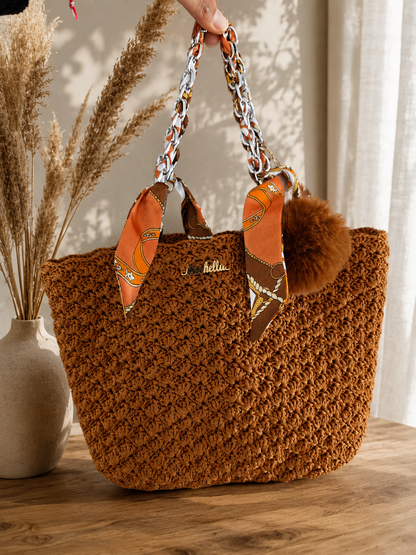 MK Lunèra Crochella Amber Luxe Handbag handcrafted crochet handbag in dark orange with scarf-wrapped chain handles.