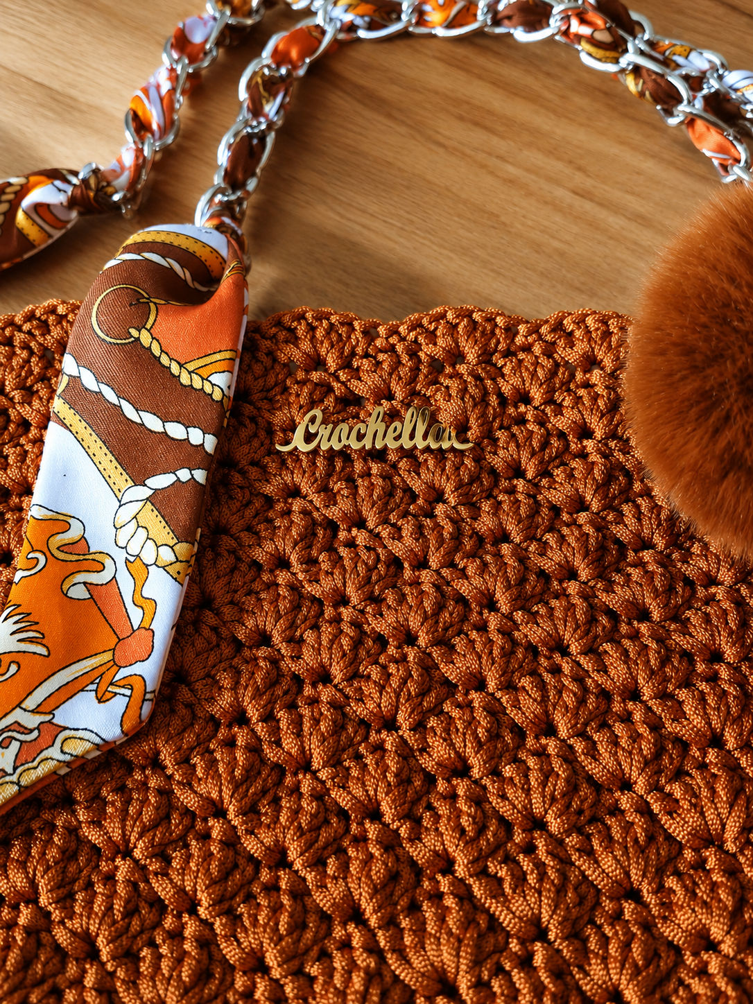 Luxury scarf-wrapped chain handle detail on the MK Lunèra Crochella Amber Luxe Handbag.