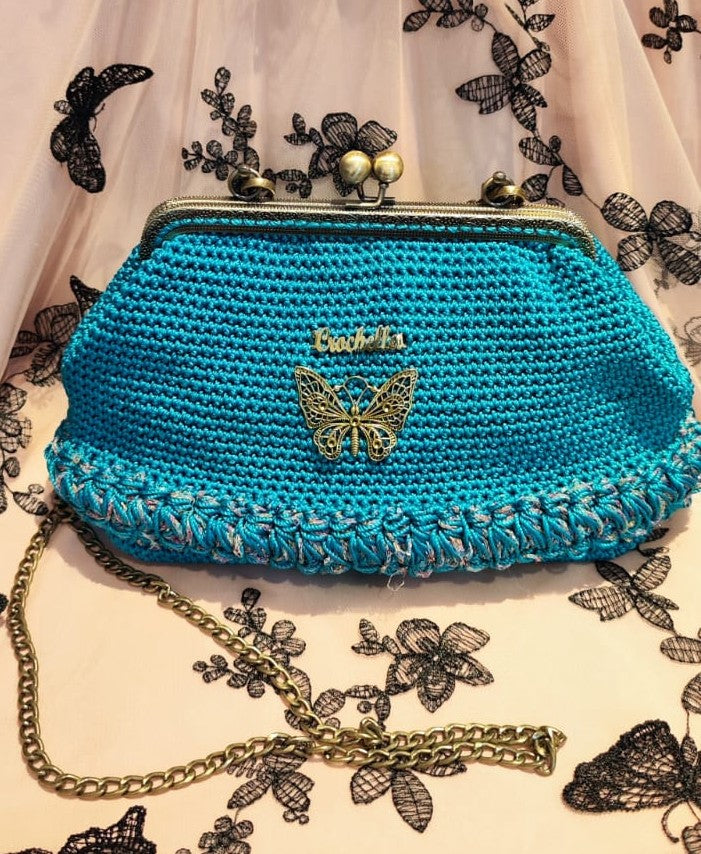 Royal Teal bag from the Royal Bloom line, featuring a bright blue crochet body with looped edging and gold butterfly charm.