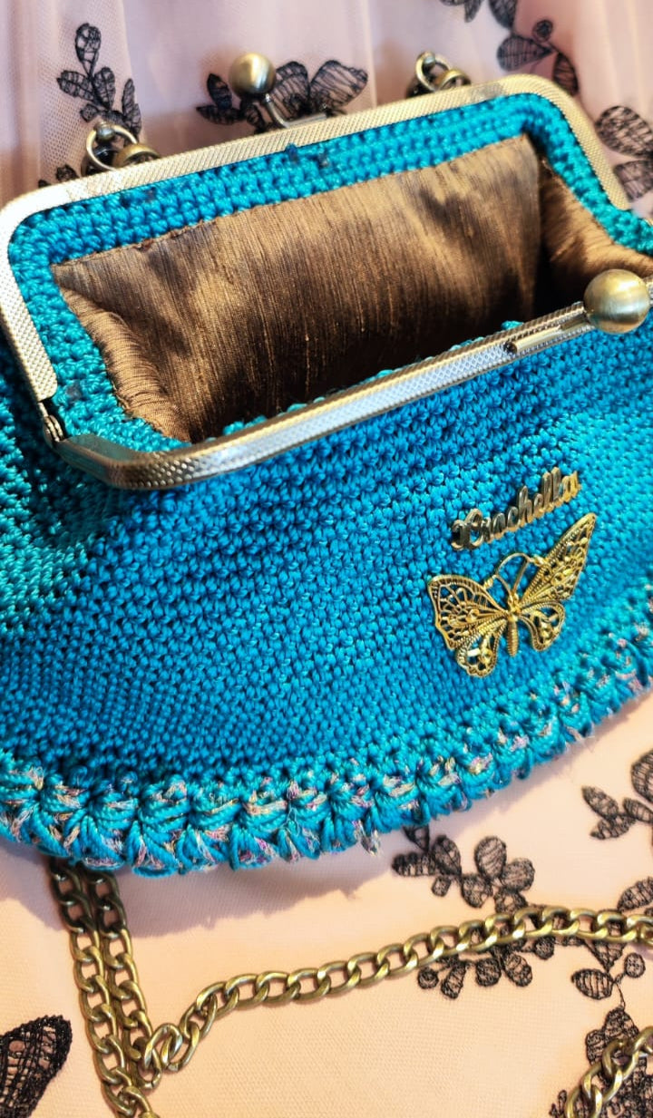 Detailed view of the Royal Teal’s fine stitchwork and embroidered butterfly logo against bold teal yarn.